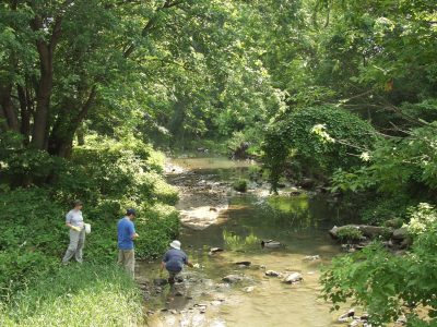Three investigators collecting streamwater samples